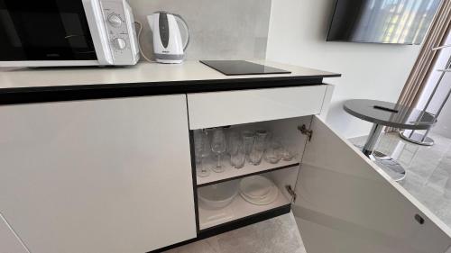 a kitchen with white cabinets and a microwave at Air conditioned 1 room Apartment Vienna Gate, 2 in Bratislava