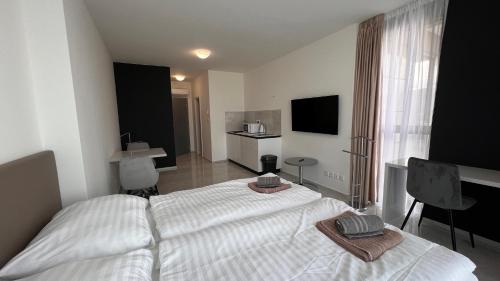 a bedroom with a large white bed and a television at Air conditioned 1 room Apartment Vienna Gate, 2 in Bratislava