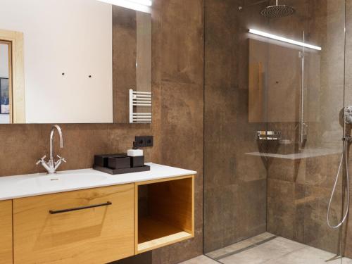 La salle de bains est pourvue d'un lavabo et d'une douche. dans l'établissement My Heimat 1495 Arlberg, à Schröcken