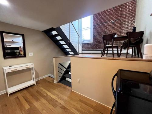 ein Wohnzimmer mit einer Treppe, einem Tisch und Stühlen in der Unterkunft Affordable & Chic RiNo/LoDo/Dtown Loft- Walkable in Denver