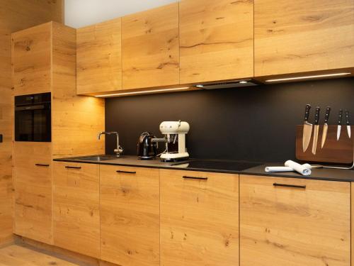 a kitchen with wooden cabinets and a mixer on a counter at Apartment in Schröcken near Ski Arlberg in Schröcken