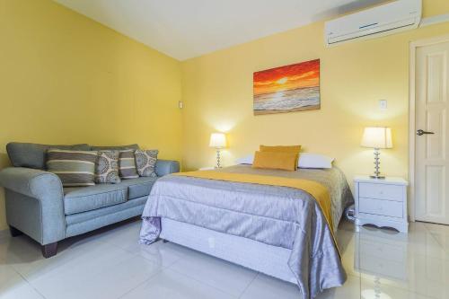 a bedroom with a bed and a couch at Juanedu Suites in Oranjestad