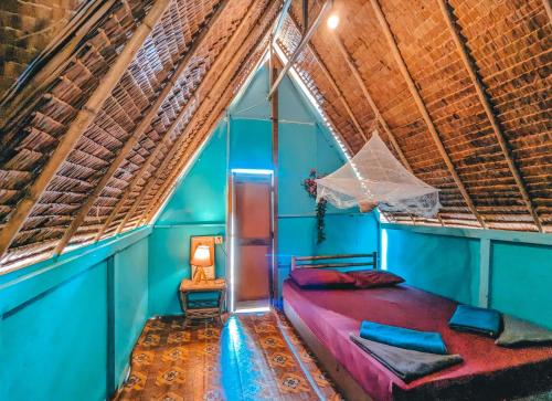 a bed in a room with a thatched roof at Yellow Sun Kampot in Kampot