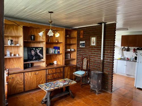 a living room with wooden cabinets and a brick wall at Cabaña en Esquel para 3 personas in Esquel