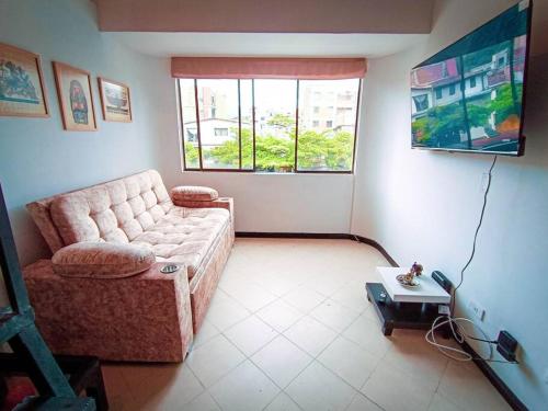 salon z kanapą i stołem w obiekcie Amplio duplex con terraza privada. w mieście Medellín