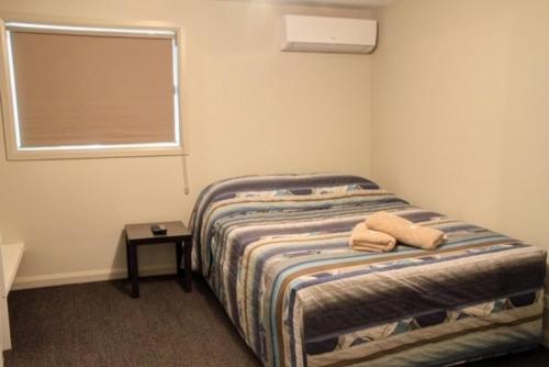 a bedroom with a bed with two towels on it at Ivanhoe Hotel Motel in Ivanhoe