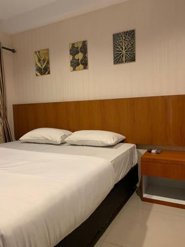 a bedroom with a large bed with a wooden headboard at Niar P in Sunggal