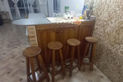 a kitchen with a bar with four wooden stools at el quincho in Mercedes