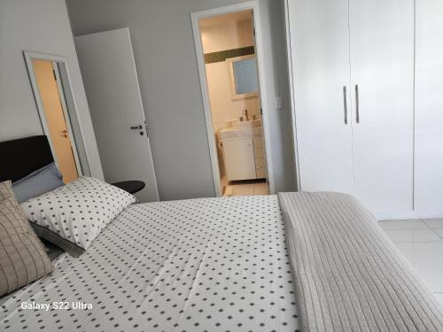 a bedroom with a large bed and a bathroom at Condomínio Encantador (Blue das Americas) in Rio de Janeiro