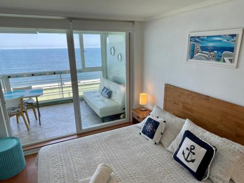 1 dormitorio con cama y vistas al océano en El Encanto de Reñaca viña del mar, Excelente vista al mar bajada directa a la playa, en Viña del Mar