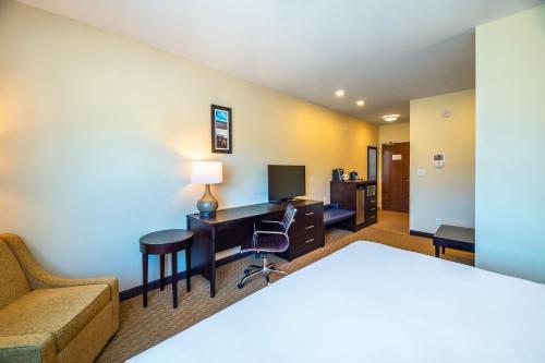 a hotel room with a bed and a desk with a computer at Comfort Inn & Suites in Terrace