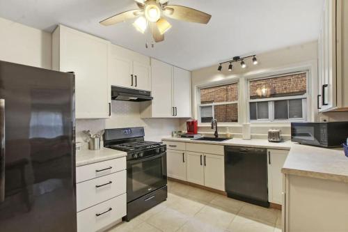 cocina con armarios blancos y ventilador de techo en Condo by the park & lake in the heart of Evanston!, en Evanston