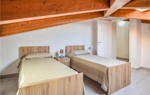 Duas camas num quarto com tectos em madeira em 2 Bedroom Nice Home In Castellabate -sa- em Santa Maria di Castellabate