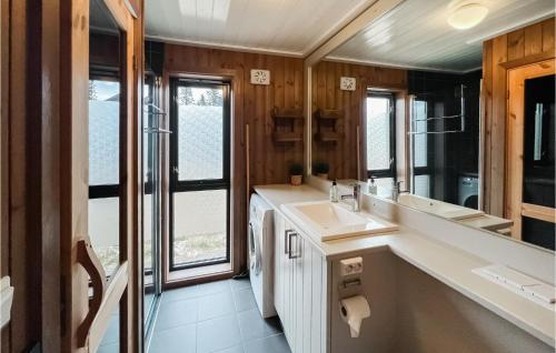 a bathroom with a sink and a large mirror at Cozy Home In Sjusjen With Kitchen in Sjusjøen