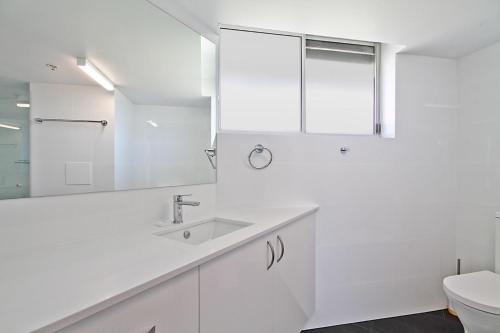 Baño blanco con lavabo y aseo en Ocean Plaza Unit 835 en Gold Coast