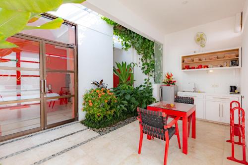 a kitchen and dining room with a red table and chairs at Bali Ginger Suites & Villa in Seminyak