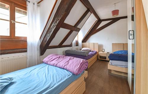 two beds in a room with wooden ceilings at Amazing Apartment In Rouffach With 2 Bedrooms And Wifi in Rouffach