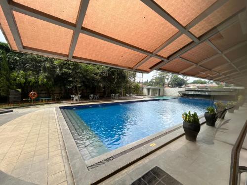 ein großer Pool mit Sonnenschirm auf einem Gebäude in der Unterkunft Studio at Galeri Ciumbuleuit Apartment 2 in Bandung