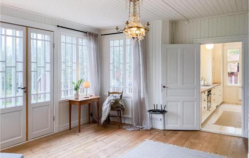 un bureau avec un lustre, un bureau et des fenêtres dans l'établissement Awesome Home In deshg With Wifi, à Ödeshög