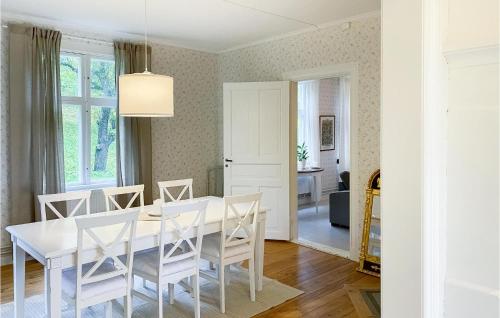 a white dining room with a white table and chairs at 4 Bedroom Stunning Home In Ödeshög in Ödeshög
