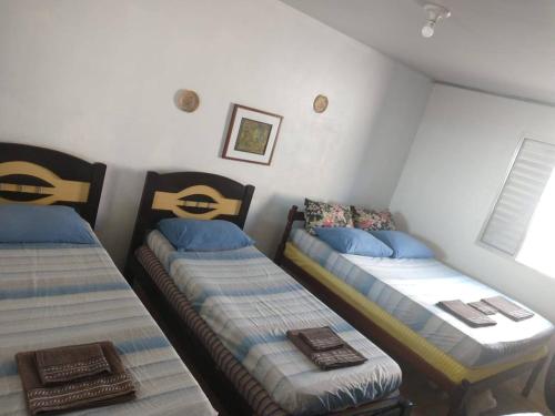 a room with two twin beds and a window at Casa Aconchegante Frente ao Mar Guaratuba in Guaratuba
