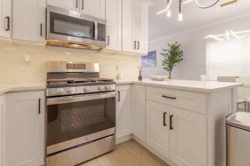 a white kitchen with a stove and a microwave at Beautiful 3bedroom apartment in Elizabeth