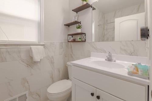 a white bathroom with a toilet and a sink at Beautiful 3bedroom apartment in Elizabeth