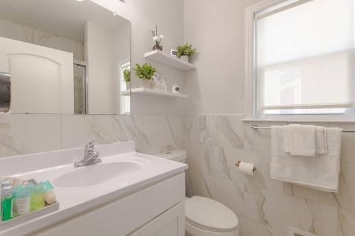 a white bathroom with a sink and a toilet at Beautiful 3bedroom apartment in Elizabeth