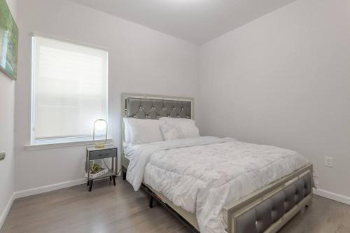 a white bedroom with a large bed and a window at Beautiful 3bedroom apartment in Elizabeth