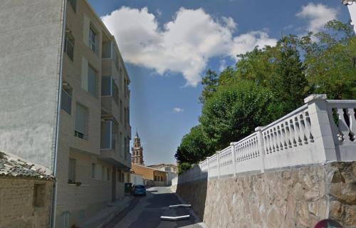 a street with a white fence and a building at Apartamento Rural El Estrecho de Arguedas in Arguedas