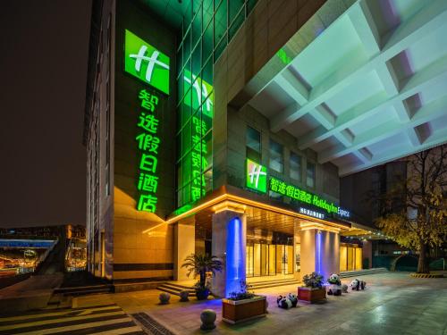 a building with green lights on it at night at Holiday Inn Express Chengdu Tianfu Square by IHG - Chunxi Road and Kuanzhai Alley in Chengdu
