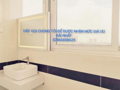 a bathroom with a white sink and a window at KHÁCH SẠN CÚC PHƯƠNG in Dĩ An