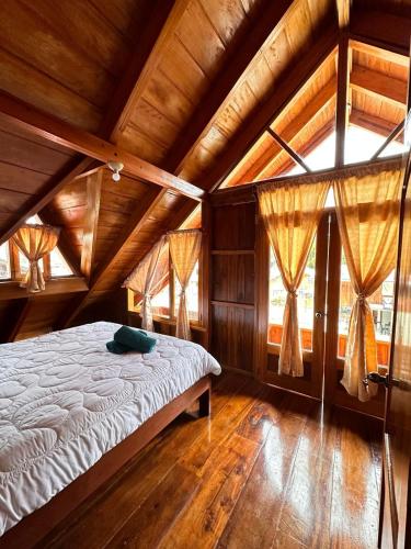 a bedroom with a bed in a room with wooden ceilings at TONYs HOUSE MINDO in Mindo