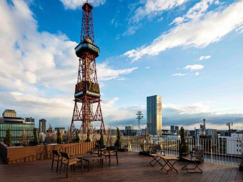 a eiffel tower with tables and chairs on a patio at The Royal Park Canvas - Sapporo Odori Park in Sapporo