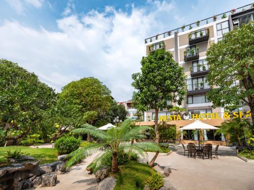 a hotel with tables and chairs in front of a building at Nesta Hotel & Spa in Hanoi