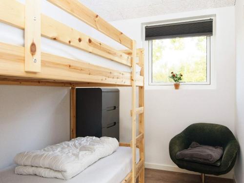 een slaapkamer met een stapelbed en een stoel bij Holiday home Allingåbro XII in Allingåbro