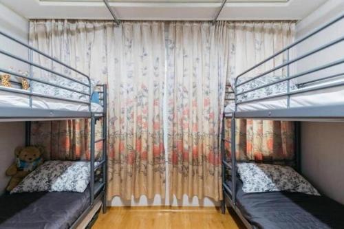 首爾的住宿－Good Stay Itaewon，一间卧室设有两张双层床和窗帘