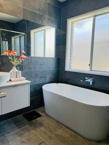 Moreton Bay Oasis في كابولتشر: حمام مع حوض أبيض ونافذة