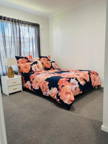 Moreton Bay Oasis في كابولتشر: غرفة نوم مع سرير وبطانية ورد