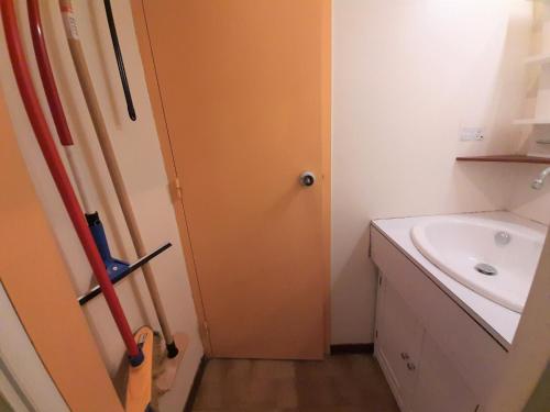 une salle de bain avec une porte orange à côté d'un lavabo dans l'établissement Studio confortable à Capbreton, à 2 pas des plages et du port, pour 3 pers, avec Wifi et ménage inclus - FR-1-239-930, à Capbreton