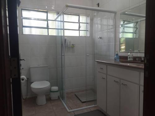 a bathroom with a shower and a toilet and a sink at Chacara Recanto Paraíso Guacuri 2 in Itupeva