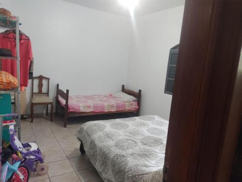 1 dormitorio pequeño con 2 camas y 1 silla en Chacara Recanto Paraíso Guacuri 2 en Itupeva