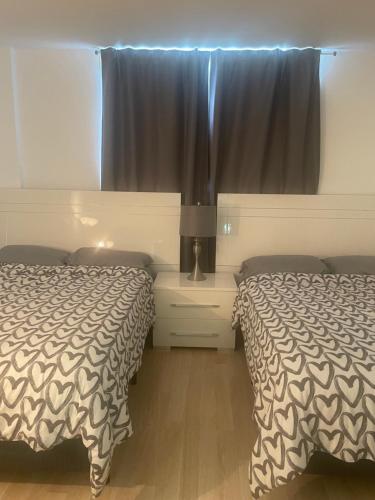 a bedroom with two beds and a window with curtains at Ocean Reserve STR-01045 in Miami Beach