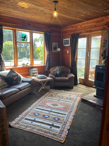 a living room with a couch and a rug at Classic Kiwi bach in Granity