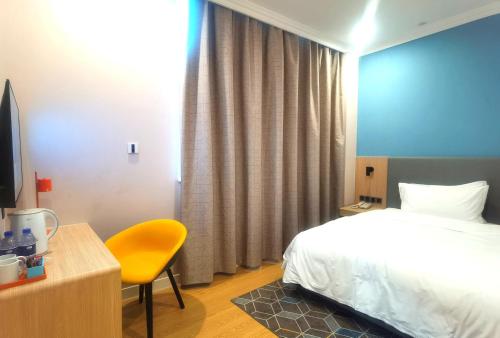 a hotel room with a bed and a yellow chair at Holiday Inn Express Chengdu Tianfu Square by IHG - Chunxi Road and Kuanzhai Alley in Chengdu