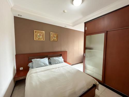 Schlafzimmer mit einem Bett und einer Glasschiebetür in der Unterkunft Super Studio Galeri Ciumbuleuit 1 (1BR, 1BA, Kitchen) in Bandung