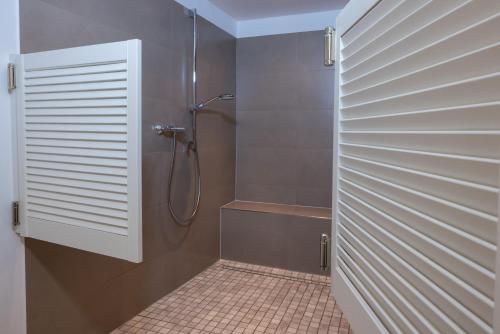La salle de bains est pourvue d'une douche avec une porte en verre. dans l'établissement Stadthaus Flensburg, à Flensbourg