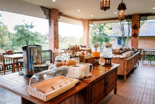 a restaurant with a table with food on it at Sawasdee Sukhothai Resort in Sukhothai