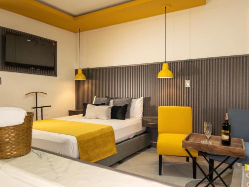 Habitación de hotel con cama y silla amarilla en Hotel velero en Roldanillo
