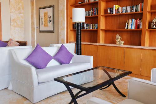 a living room with a white couch and purple pillows at Sheraton Jinan Hotel in Jinan
